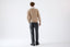 Model wearing beige merino wool crew neck jumper with white shirt by Roksolana, back view.
