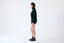 Model wearing black merino wool-blend knitted shorts with a green jumper, side view.