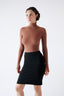 Model wearing a black merino skirt on a white background