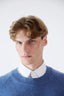 Close-up of model wearing blue merino-cashmere blend crew neck jumper with white shirt underneath.