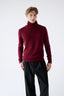 Model wearing burgundy merino wool turtleneck jumper, full-body front view.