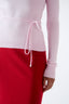 Close-up of pink merino wool turtleneck jumper showing tie detail at the waist.