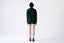Model wearing dark green merino wool turtleneck jumper, back view.