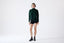 Model wearing dark green merino wool turtleneck jumper, front view.