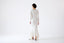 Model wearing ivory merino-alpaca long-sleeve knitted dress, back view.