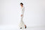 Model wearing ivory merino-alpaca long-sleeve knitted dress with flared hem, front view.