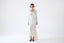 Model wearing ivory merino-alpaca long-sleeve knitted dress with flared hem, front view.