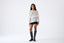 Model wearing ivory mohair wool-blend oversized poncho with black mini skirt and boots, front view.