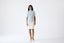 Model wearing light blue merino wool short-sleeve turtleneck jumper.