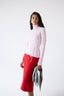 Model wearing light grey merino wool-angora triangle scarf with pink jumper and red skirt, front view.