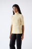 Model wearing a light yellow turtleneck wool jumper 