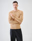 Model wearing beige merino wool jumper, back view, close-up view