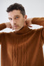 Close-up of model wearing brown merino-cashmere blend turtleneck jumper by Roksolana.