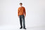 Model wearing orange cashmere wool turtleneck jumper, full-body front view.