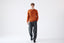 Model wearing orange cashmere wool turtleneck jumper, full-body front view.