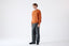 Model wearing orange cashmere wool turtleneck jumper, side view.
