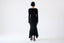 Model wearing a black dress on a white background