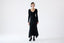 Model wearing a black dress on a white background