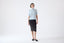 Woman wearing a light blue top and dark brown skirt on a white background