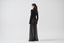 Model wearing black sheer mohair-alpaca knit maxi skirt with long-sleeve black top, side view.