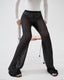 Model wearing black sheer mohair-alpaca knit trousers with white top, front view.