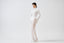 Model wearing white sheer mohair-alpaca knit maxi skirt with white top, front view.