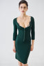 Model wearing emerald green fitted merino wool cardigan with matching skirt, front view.