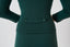 Close-up of emerald green fitted merino wool cardigan showing tonal buttons and fine knit texture.
