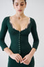 Model wearing emerald green fitted merino wool cardigan with scoop neckline, close-up view.