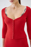 Model wearing red fitted merino wool cardigan with scoop neckline, close-up view.